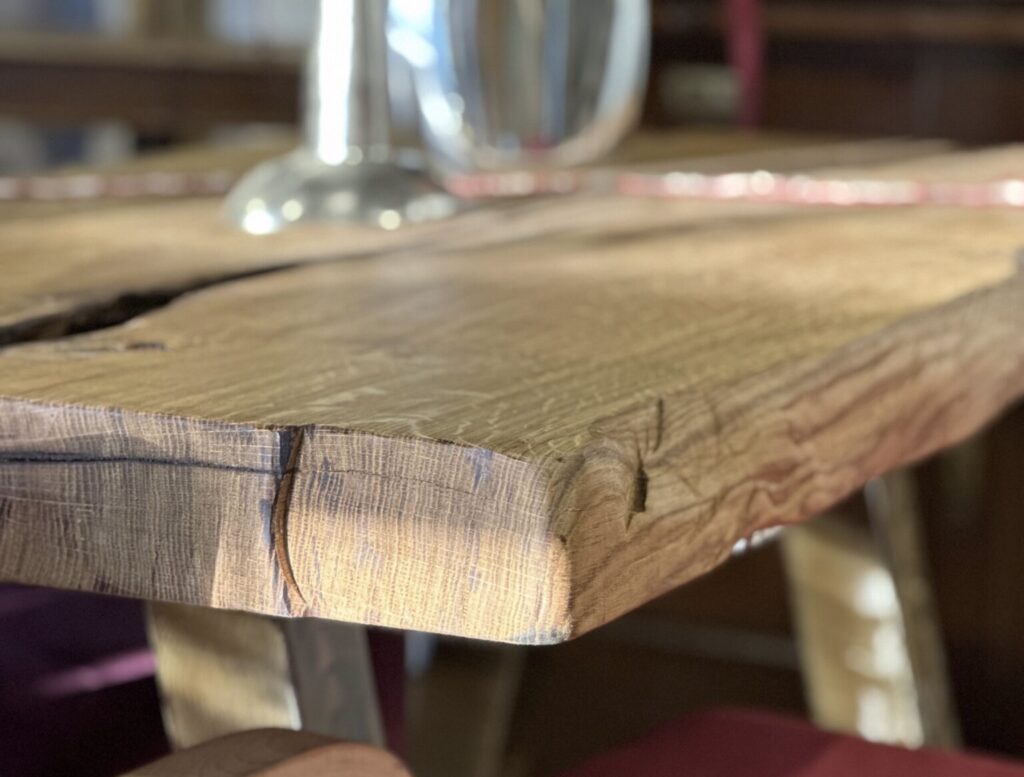 Massive Holztischplatte mit markanter Maserung und natürlicher Kante im Möbel-Bahnhof Bielefeld