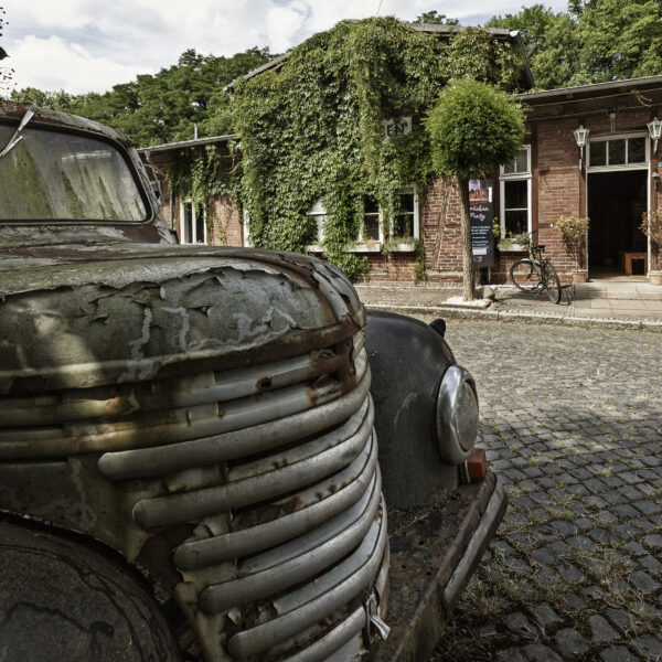 Verwitterter Hanomag vor dem historischen Backsteingebäude des Möbel-Bahnhofs Bielefeld“