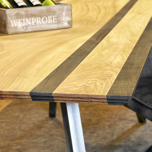 Massivholztisch im Möbel-Bahnhof Bielefeld, gefertigt in zwei unterschiedlichen Holzarten mit markanter Maserung und stabilem Gestell.