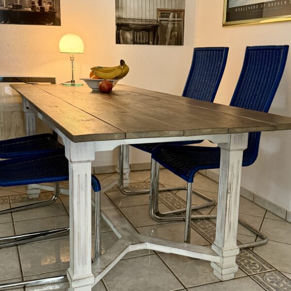Alter Esstisch aus dem Möbel-Bahnhof im Esszimmer. Der restaurierte Holztisch mit weißem Untergestell war viele Jahre Teil des Eventbahnhofs und dient heute als Esstisch.